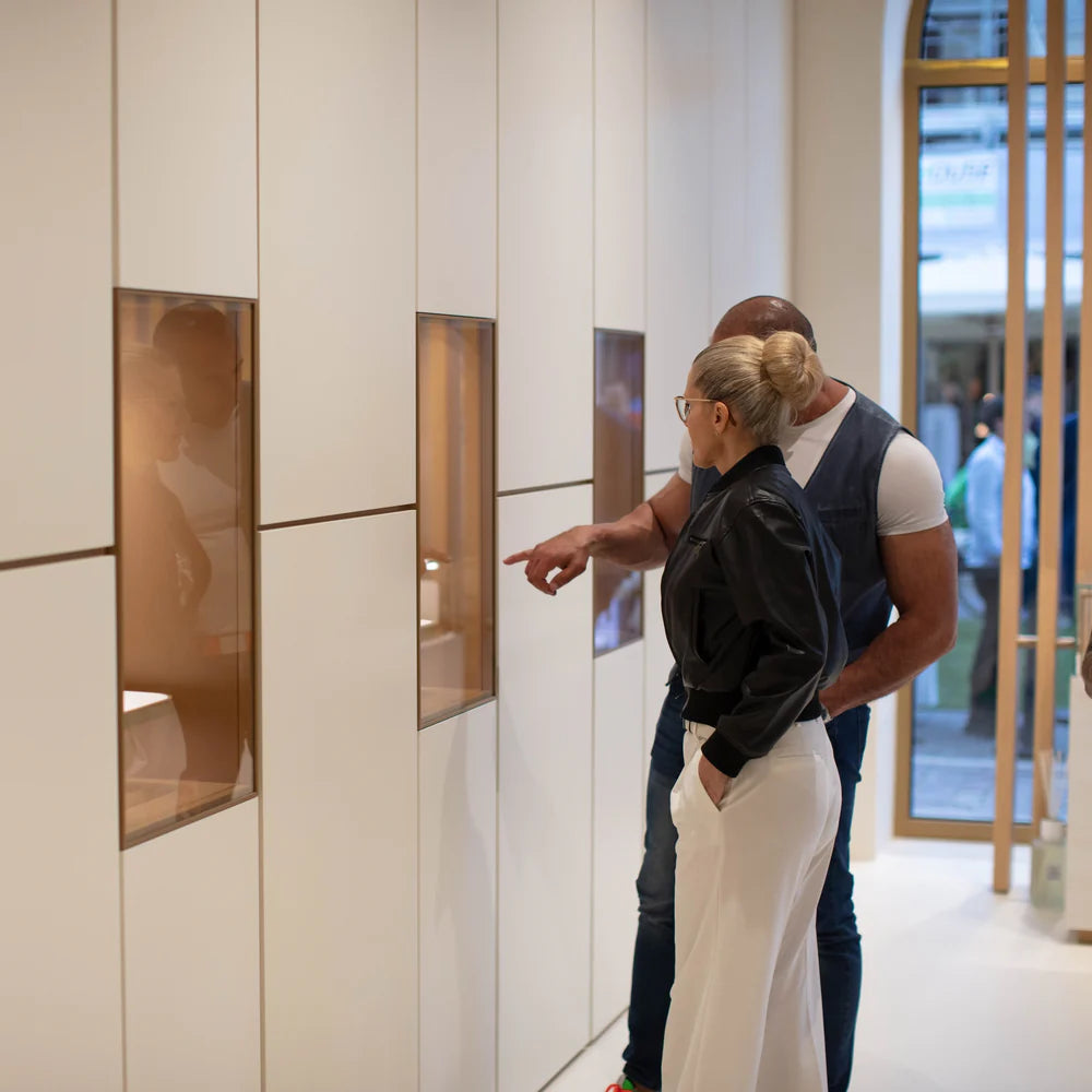 Due clienti che osservano l'esposizione degli orologi il giorno dell'inaugurazione dell'Atelier Venezianico a San Donà di Piave